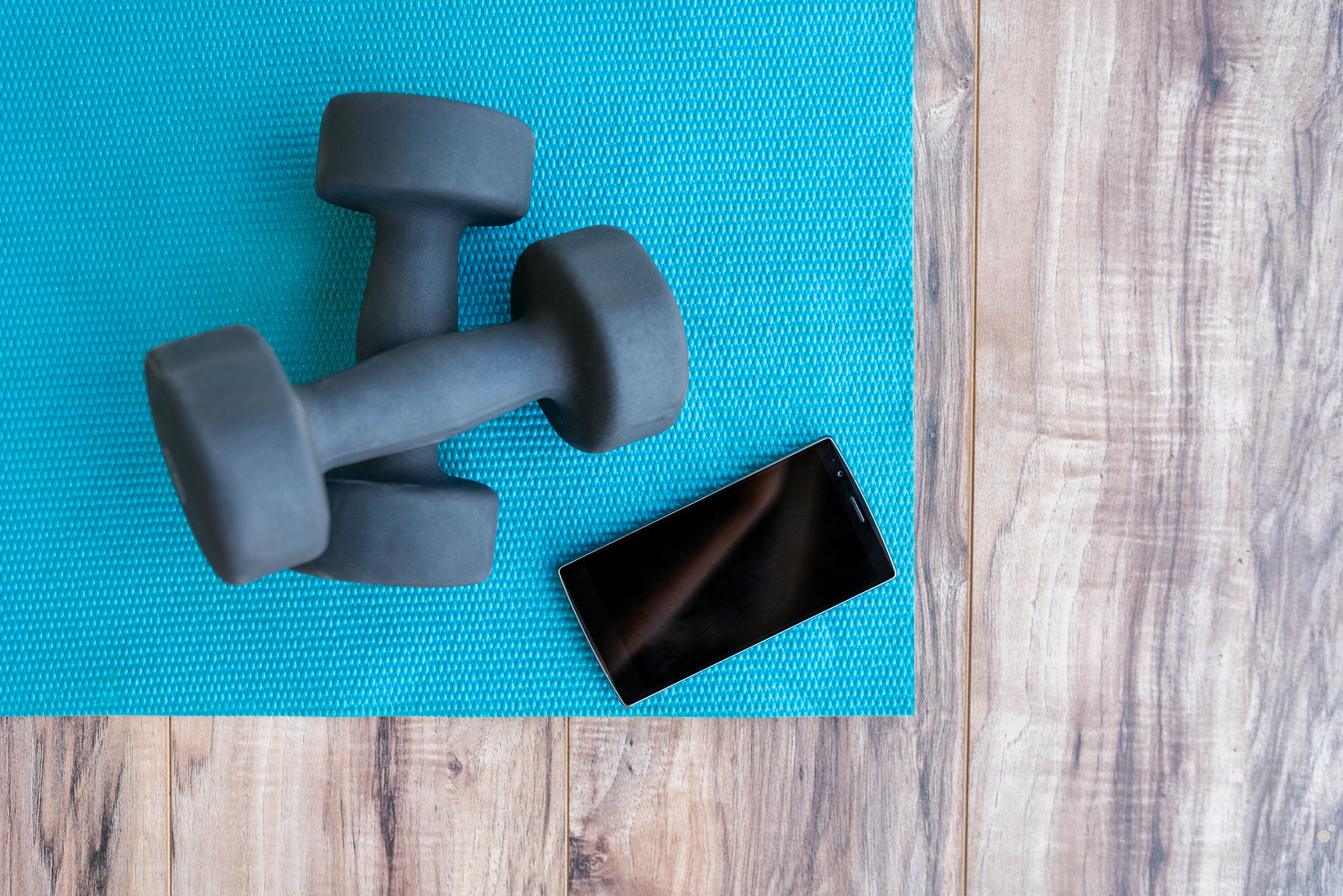 Fitness at home: free weights, yoga mat, mobile phone app. Dumbb