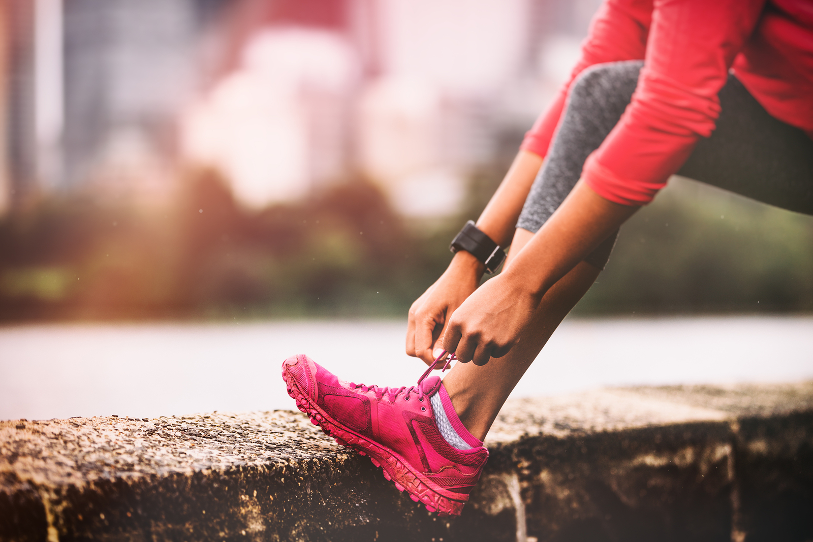 Runner woman getting ready to run tying running shoes laces. Hea