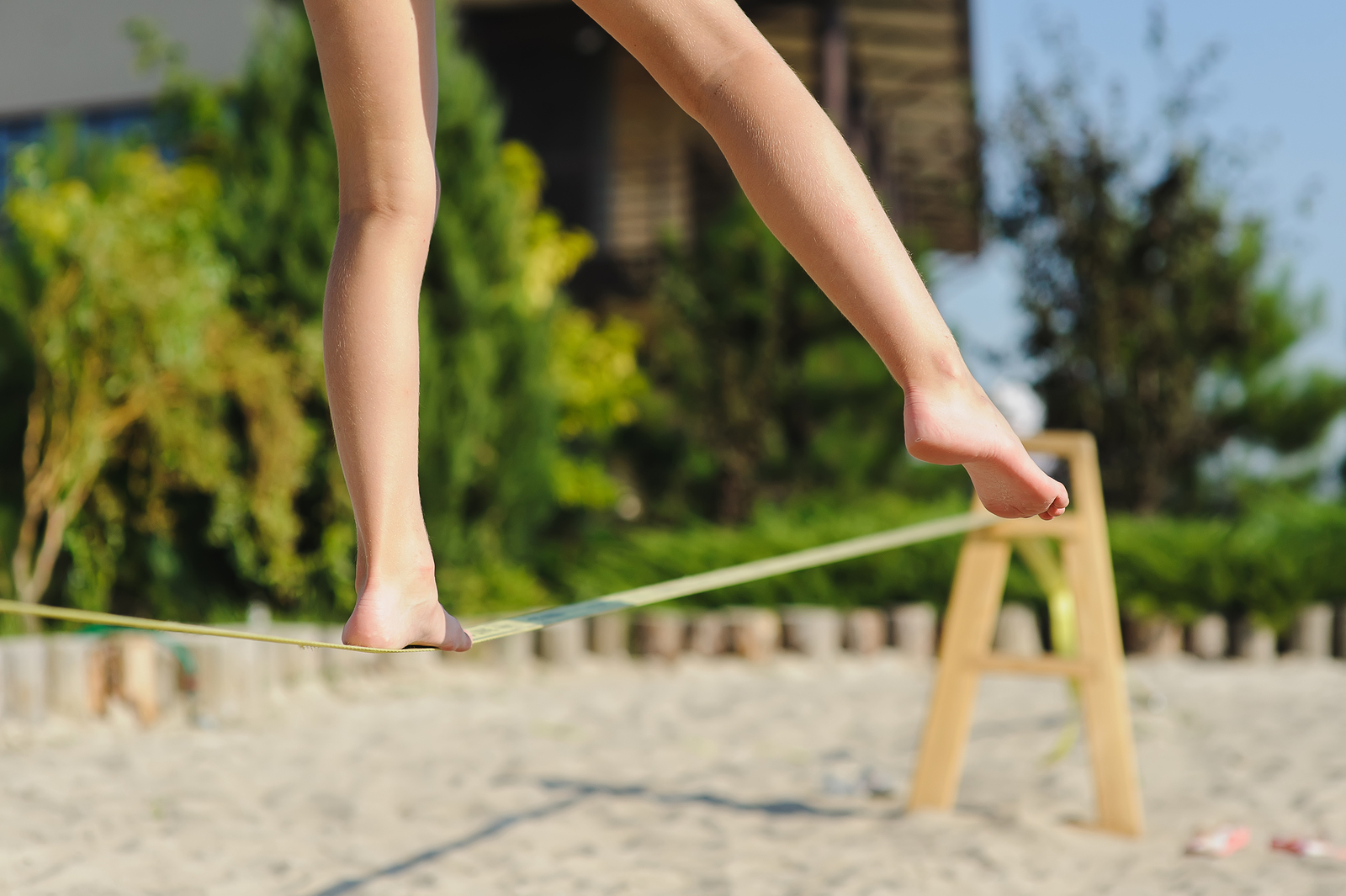 Girl walking on the sling. Child balancing