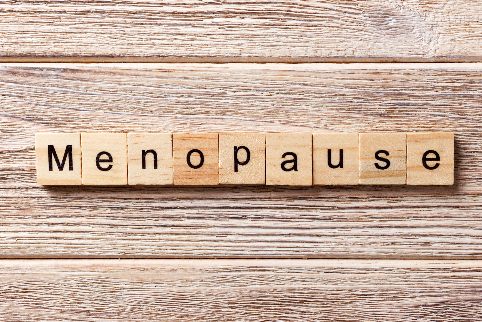 menopause word written on wood block. menopause text on table concept.