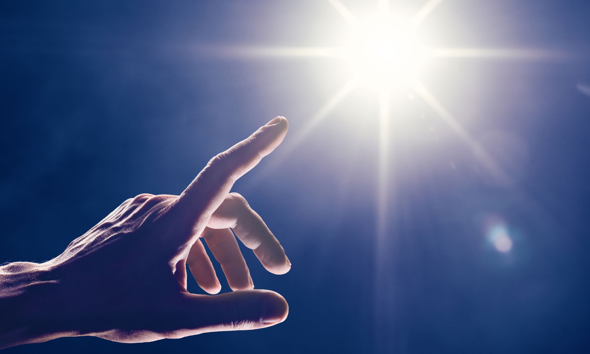 Image shows a close up of a man's hand pointing at a star light to signify the value of human touch in relation to translation of online courses for rehabilitation professionals on Physiopedia Plus online learning for Physiotherapists, Physical Therapists and Rehabilitation Professionals