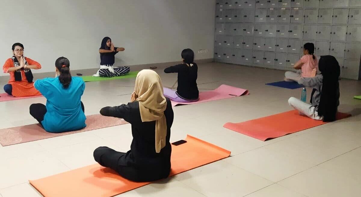 Image shows participants of a novel class-based physical activity programme taking part in a yoga post on mats. Image links to the Physical Activity Programme of online courses on Physiopedia Plus onlnine learning for Physiotherapists, Physical Therapists and Rehabilitation Professionals.